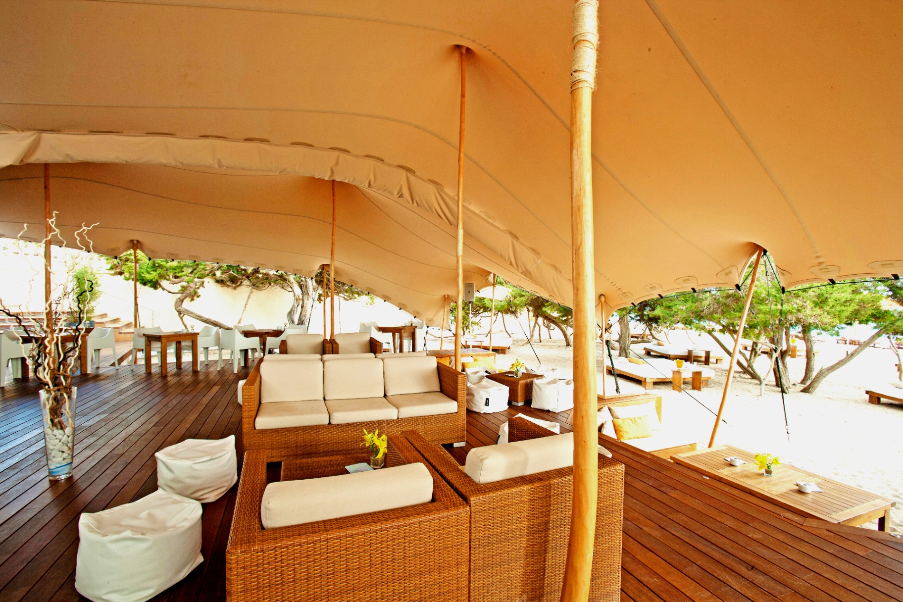 Zona lounge bajo la carpa con sofás frente a la playa