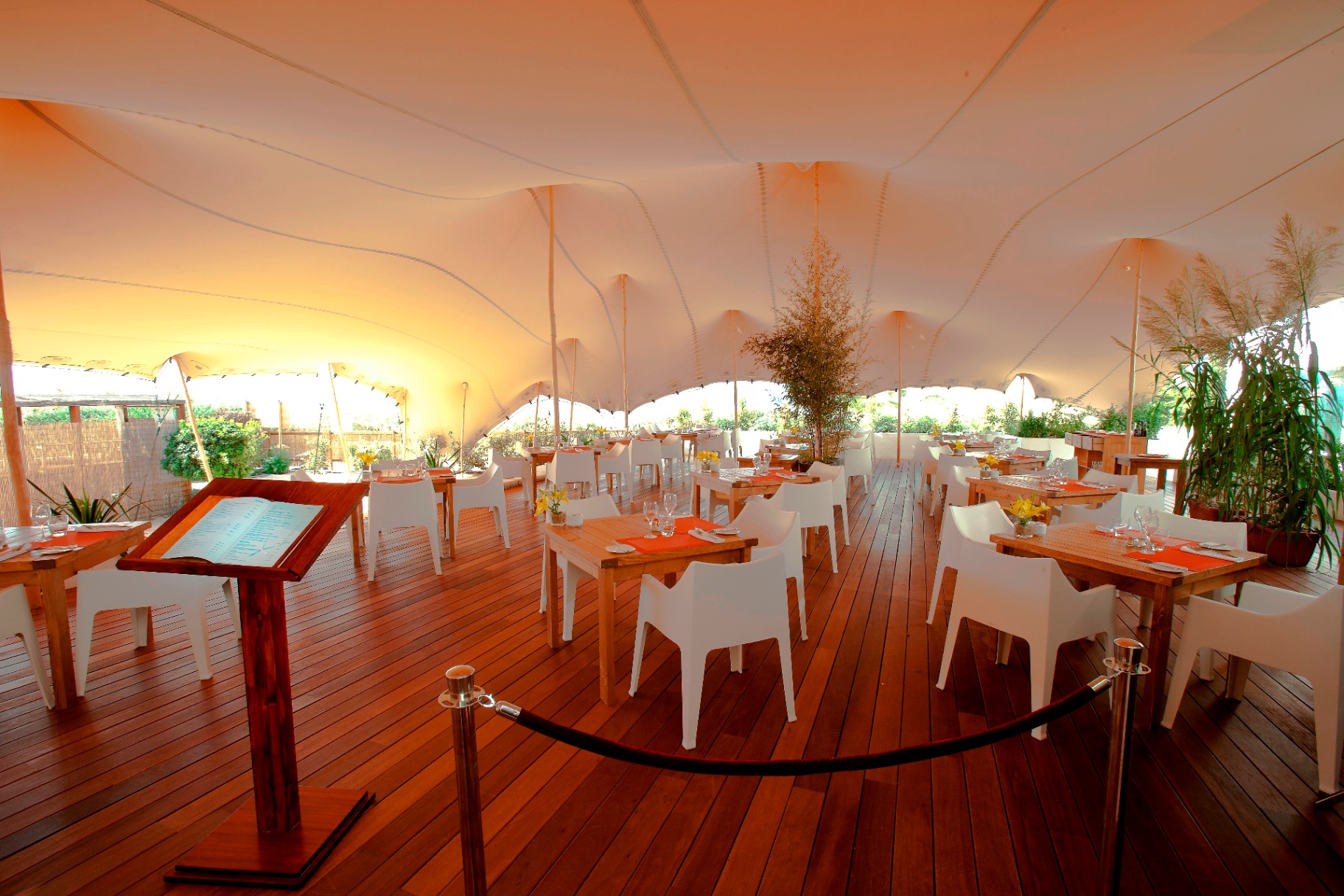 Comedor bajo carpa al atardecer con mesas dispuestas