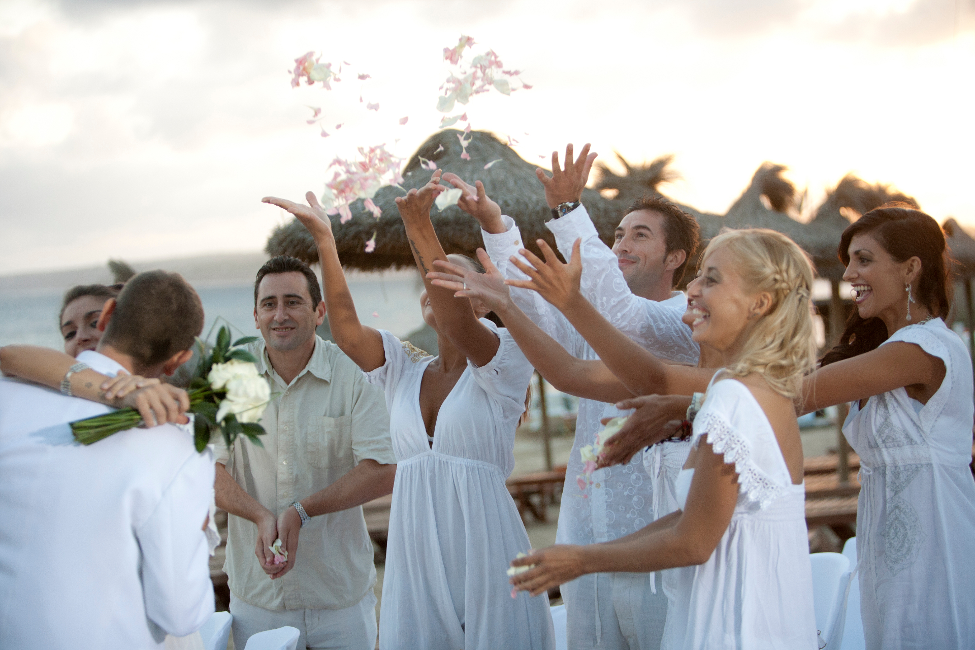 Celebración de boda lanzando pétalos frente al mar